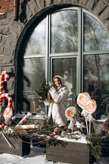 A woman walks along a city street on Christmas Eve in search of gifts and a good mood