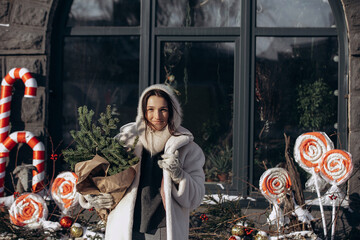 A woman walks along a city street on Christmas Eve in search of gifts and a good mood