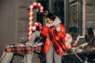 A woman walks along a city street on Christmas Eve in search of gifts and a good mood