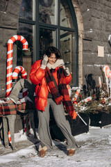 A woman walks along a city street on Christmas Eve in search of gifts and a good mood