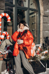 A woman walks along a city street on Christmas Eve in search of gifts and a good mood