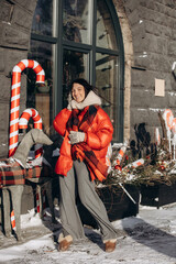 A woman walks along a city street on Christmas Eve in search of gifts and a good mood