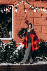 A woman walks along a city street on Christmas Eve in search of gifts and a good mood