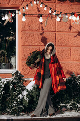 A woman walks along a city street on Christmas Eve in search of gifts and a good mood