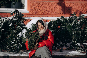 A woman walks along a city street on Christmas Eve in search of gifts and a good mood