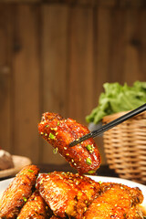 Glazed Chicken Wings with Sesame Seeds and Green Onions on White Plate