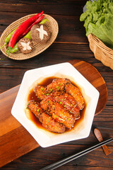 Glazed Chicken Wings with Sweet Soy Sauce and Fresh Vegetables on Wooden Table