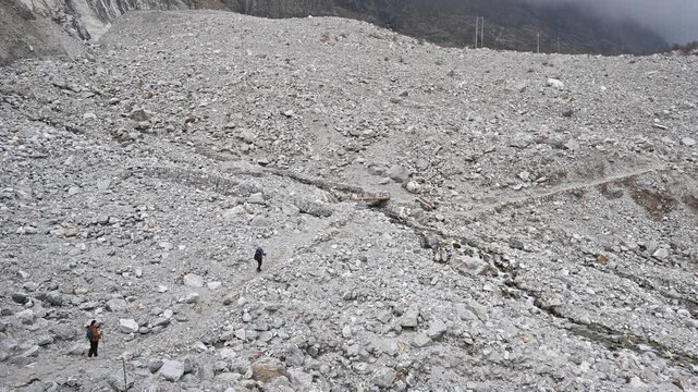 Tourist walking on Landslide area covering an old Langtang village. The 2015 earthquake triggered a catastrophic avalanche and landslide that submerged the village under a great plume of ice and rock.