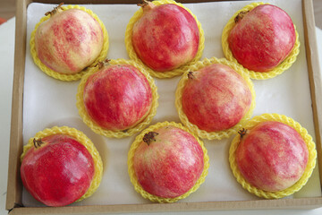 Fresh Pomegranates in Protective Mesh Packaging in Wooden Box