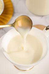 Creamy Soy Milk Pouring from Spoon - Plant-Based Dairy Replacement for Healthy Breakfast and Cooking