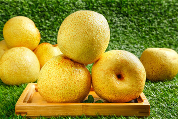Fresh Dangshan Pears from Anhui China in Wooden Crate on Green Grass Background