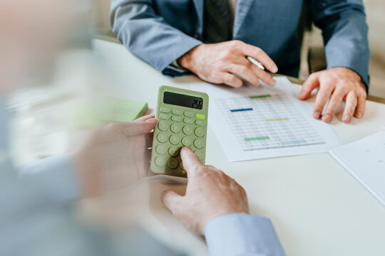 Business consultation with calculator and financial document at desk