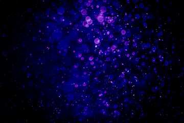 Blurred photo with purple violet and blue dots visible glittering, shining brightly look and feel luxurious