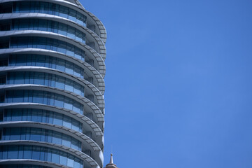 Naklejka premium A section of a modern building with many rectangular glass windows reflecting the clear