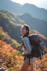 Naklejka premium Female backpacker hiking in autumn mountains