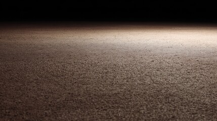 Close up of a textured dirt or gravel surface illuminated by a single light source image