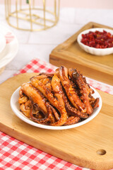 Spicy Marinated Squid Tentacles with Chili Flakes on Wooden Cutting Board
