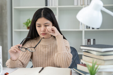 Eye problems, Asian women with tired and irritated eyes, eye rubbing, dry, eye pain after work, migraine, headache, blurred vision, photophobia, eye hurt from Read a book for a long time.