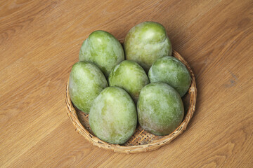 Fresh Green Mangoes in Wicker Basket on Wood Table - Tropical Fruit Collection