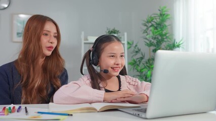 Asian loving mother support young kid daughter learning online in house. - Powered by Adobe