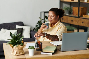 Empowered black woman finds focus while working remotely in cozy apartment space