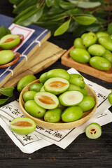 Fresh Green Chaoshan Olives in Wooden Bowl on Traditional Chinese Paper