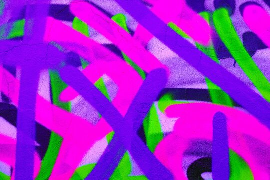 Neon graffiti art featuring vibrant streaks in purple, green, pink. 90s street style, bold patterns, fluorescent glow. Urban walls, street art projects, creative backgrounds, modern 90s visuals.
