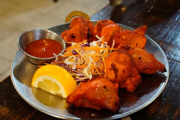Indian Chicken Tikka Served with Lemon and Salad