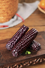 Purple Baby Corn Glutinous Variety from Xishuangbanna Yunnan Province China on Wooden Board Closeup