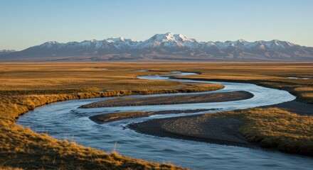 Serpentine River Winding Through Golden Plains with Snow-Capped Mountains