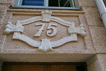 Numéro 75. Plaque de numéro de rue en relief et en plâtre.