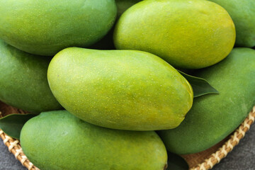 Fresh Green and Yellow Mangoes in Wicker Basket - Tropical Fruit Collection Closeup
