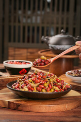 Asian stir-fried peanuts and rice dish with vegetables on wooden table traditional cooking