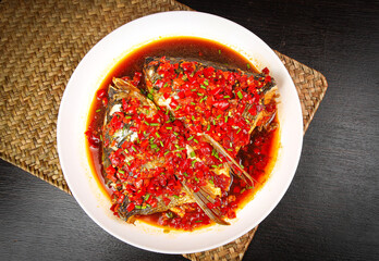 Steamed Fish Head with Spicy Chili Sauce and Red Peppers on White Plate - Traditional Asian Cuisine