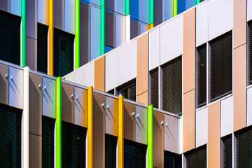 Colorful office façade with vertical green and yellow panels adding rhythm, contrast, and...