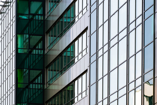 Modern building with colorful glass panels and sharp geometric lines creating dynamic architectural urban composition. - Powered by Adobe