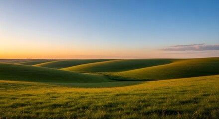 Obraz premium Rolling Green Hills Under a Golden Sunset Sky