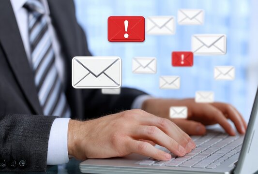 Businessman at laptop, email alerts - Powered by Adobe
