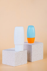 Cosmetic product in tube, bottle, lotion or serum with stylish props on cream background. 