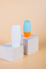 Cosmetic product in tube, bottle, lotion or serum with stylish props on cream background. 