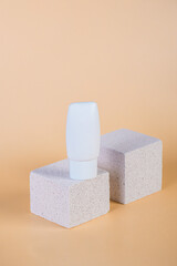 Cosmetic product in tube, bottle, lotion or serum with stylish props on cream background. 