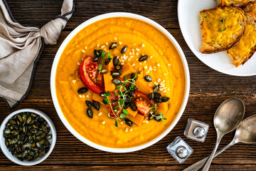 Pumpkin cream soup on wooden table