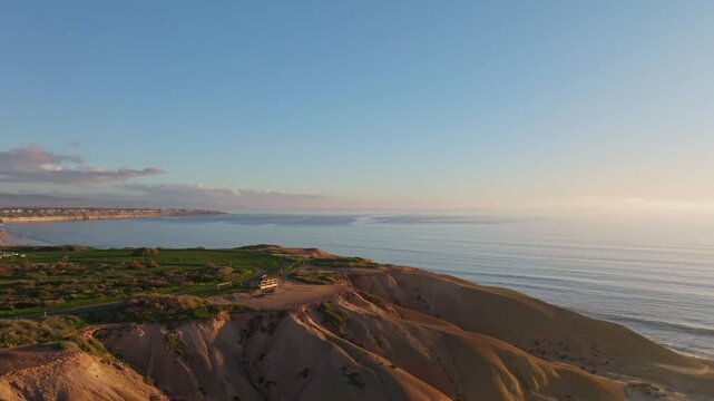 Aerial view of the rugged cliffs meeting the calm ocean, with soft light illuminating the scene, creating a serene coastal landscape, Port Willunga, South Australia, Australia.