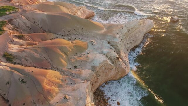 Aerial view of the rugged coastline, where the cliffs meet the ocean, contrasting textures and colors in Port Willunga, South Australia, Australia.
