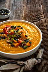 Pumpkin cream soup on wooden table