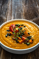 Pumpkin cream soup on wooden table