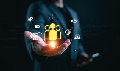 Concept of customer relationship management (CRM), digital marketing. A person holds glowing CRM icon with virtual interface, representing customer engagement, sales process, business strategy.