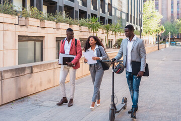 Multiracial diverse business teamwork walking and talking on city street with electric scooter