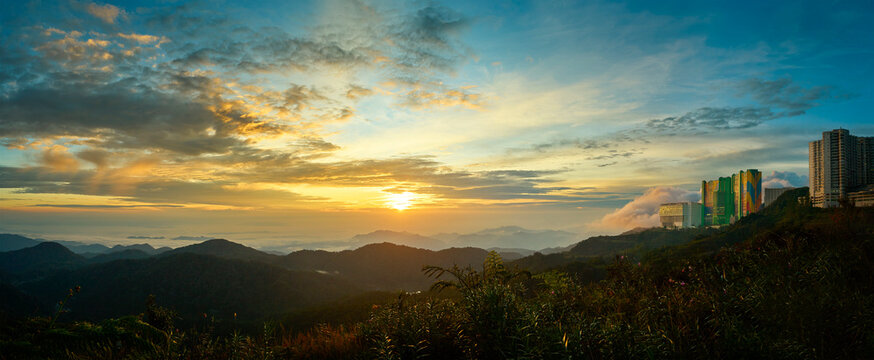 Sunrise illuminating lush valley and buildings in genting highlands, malaysia