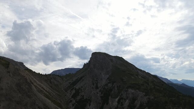 Timelapse of dramatic clouds moving over silhouetted mountain peak at Ofen Pass in Swiss National Park, Switzerland